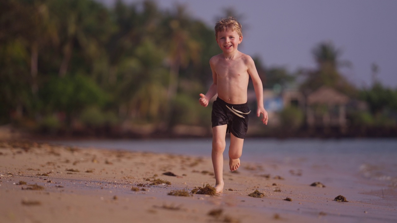 男孩在泰国海滩上快乐地奔跑视频素材