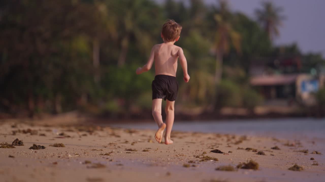 一个男孩在海边奔跑的背影视频素材