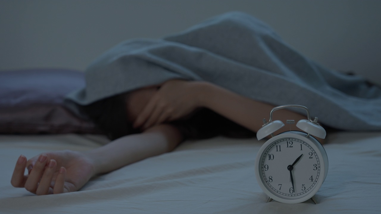 亚洲女性在床上睡得很晚，试图入睡，失眠，失眠或害怕在噩梦中，看起来悲伤，担心和压力。半夜醒来时感到疲倦、头痛或偏头痛。视频素材