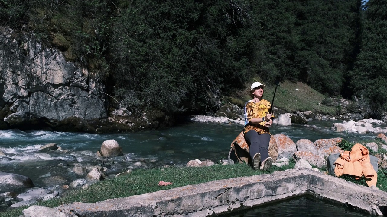 一位女视频博主正在展示山区的天然温泉视频下载