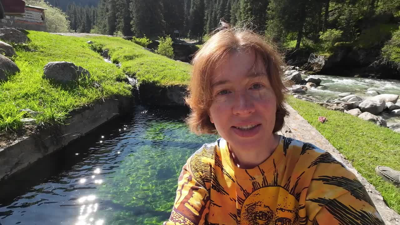一位女视频博主正在展示山区的天然温泉视频下载
