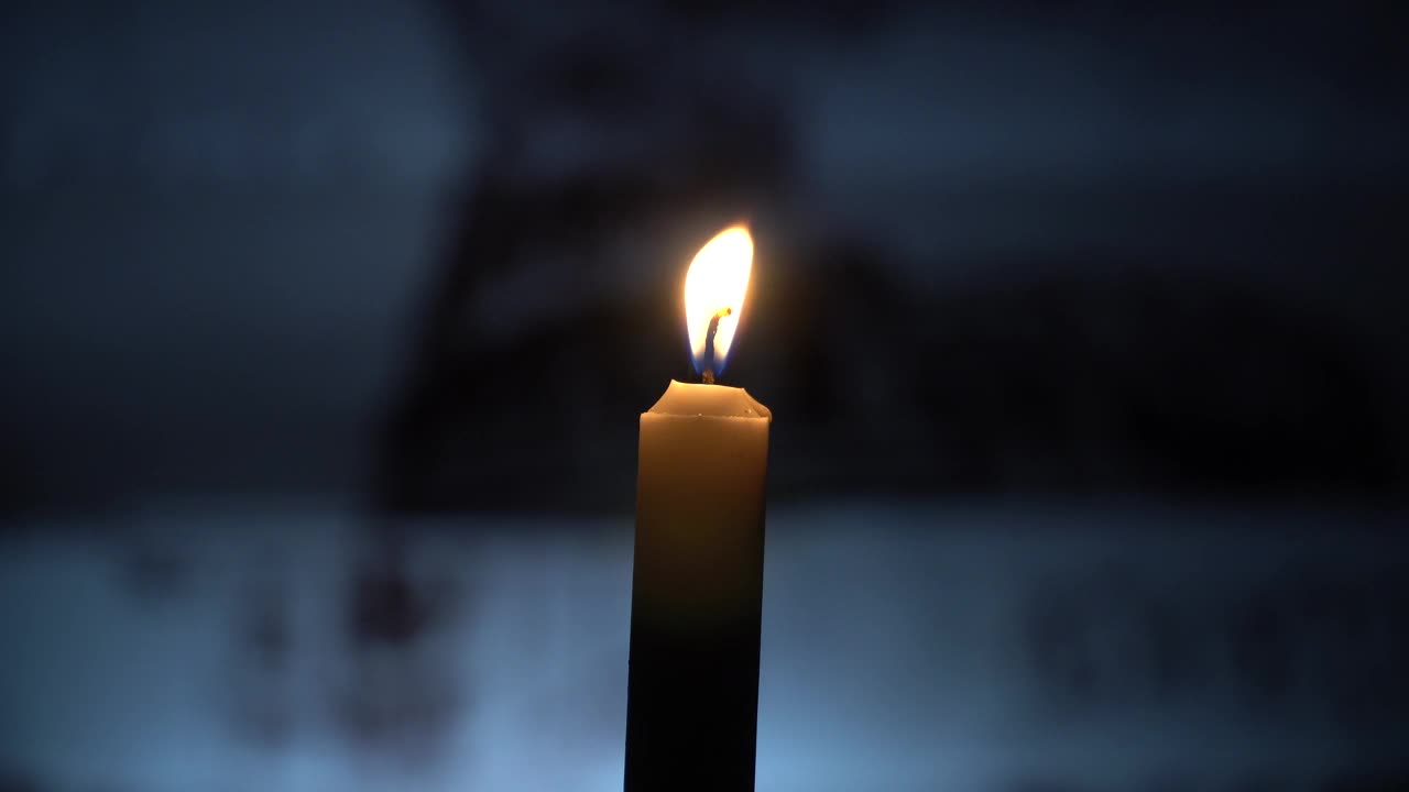 桌子上燃着的蜡烛以院子为背景视频下载