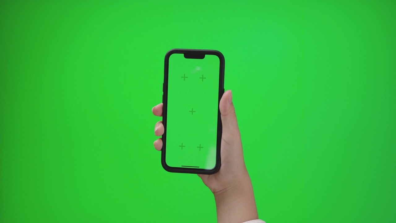 年轻女性手持智能手机，绿屏空白的模拟视频下载
