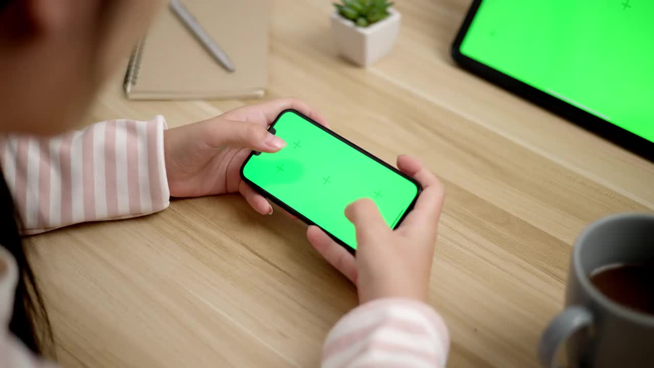 年轻女性玩游戏智能手机与空白模拟绿屏视频素材