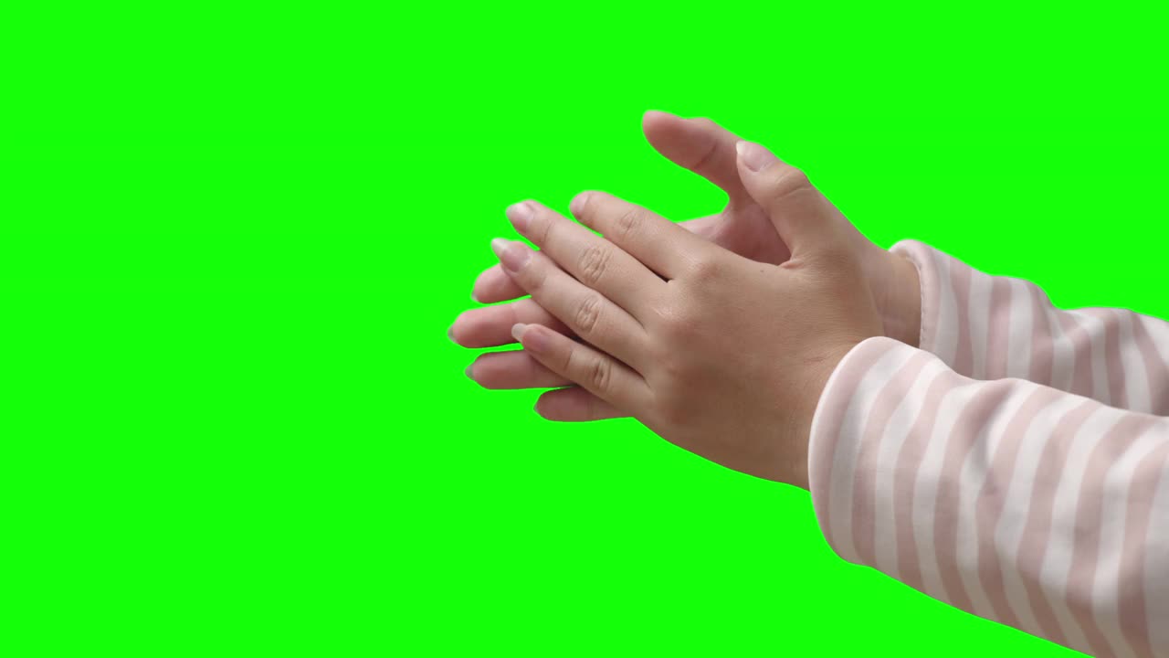 在绿色的背景上，年轻女子的手在拍手视频素材