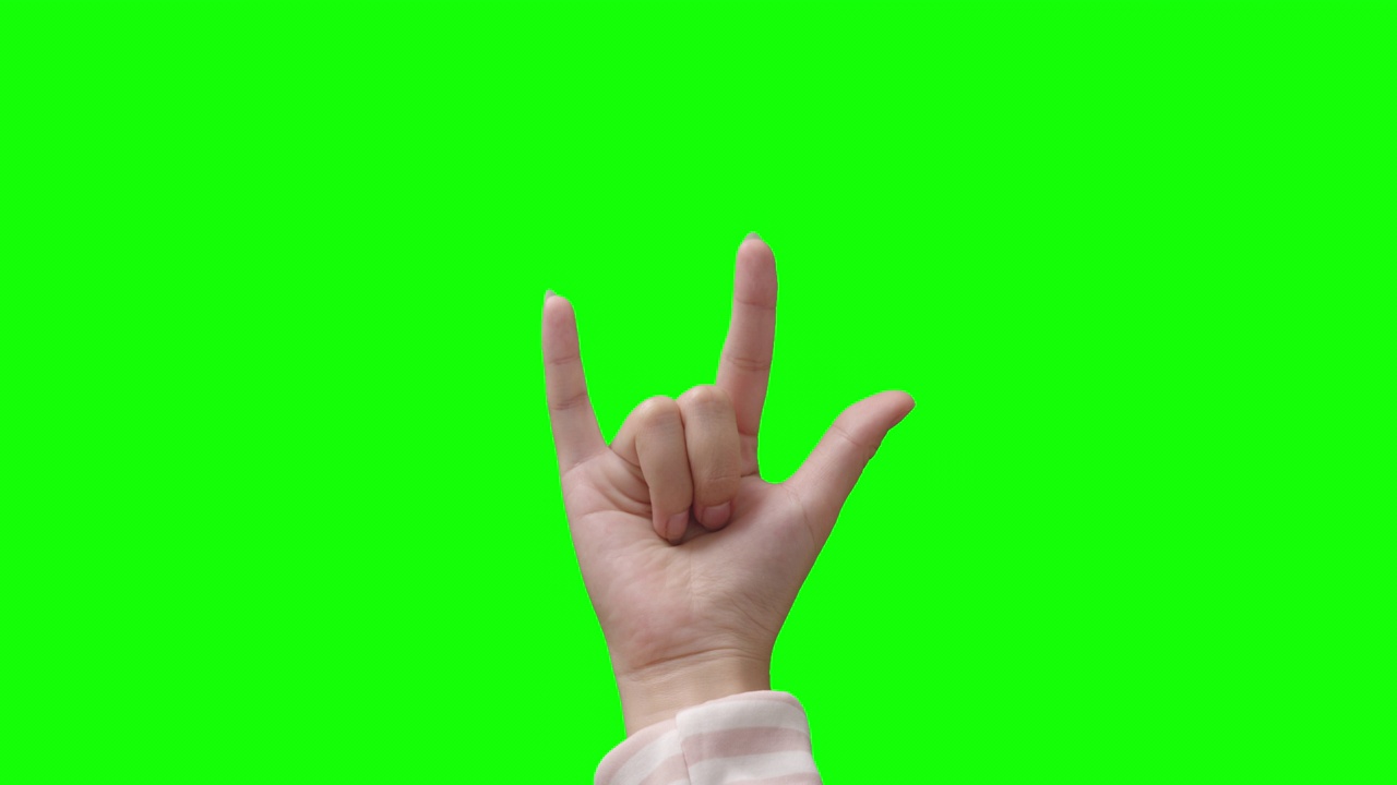 女性的手指在绿色背景上显示出爱的信号视频素材