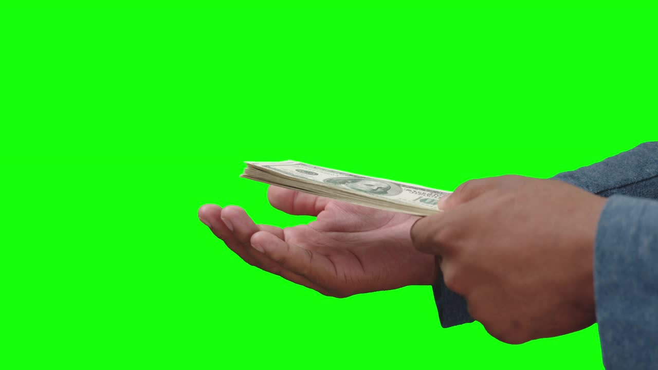 男性手里拿着一叠美元钞票，另一只手掌拍打着视频下载