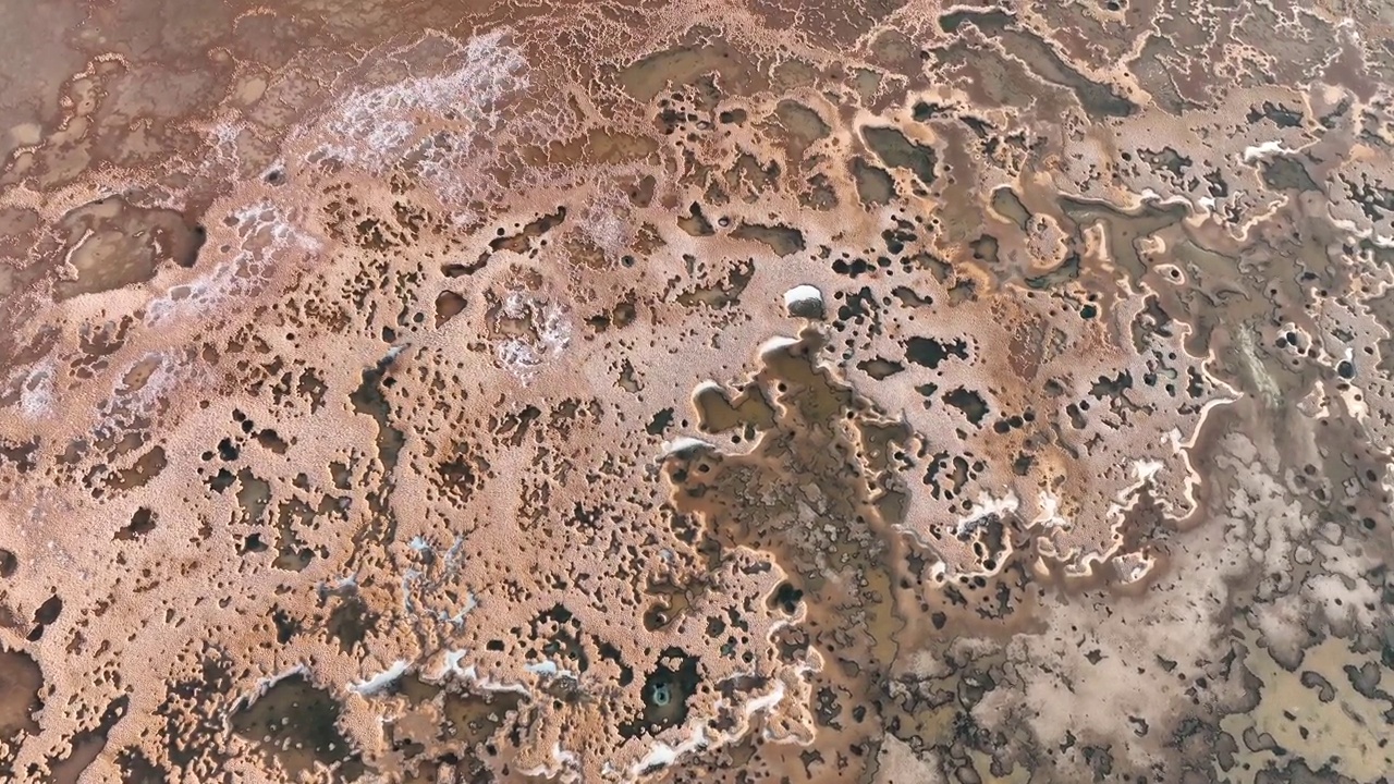 白天的无人机镜头揭示了埃及锡瓦绿洲抽象盐层的迷人之美。视频下载