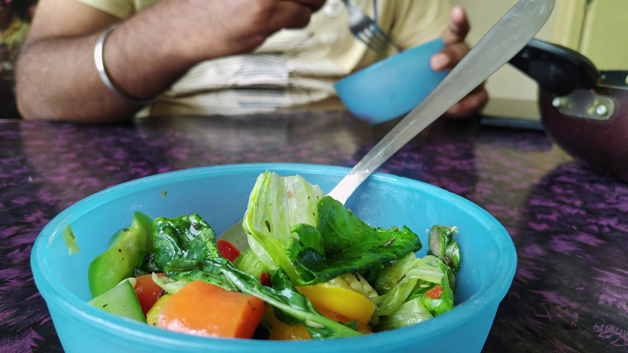 早餐时盛在塑料碗里的新鲜蔬菜沙拉的特写视频素材