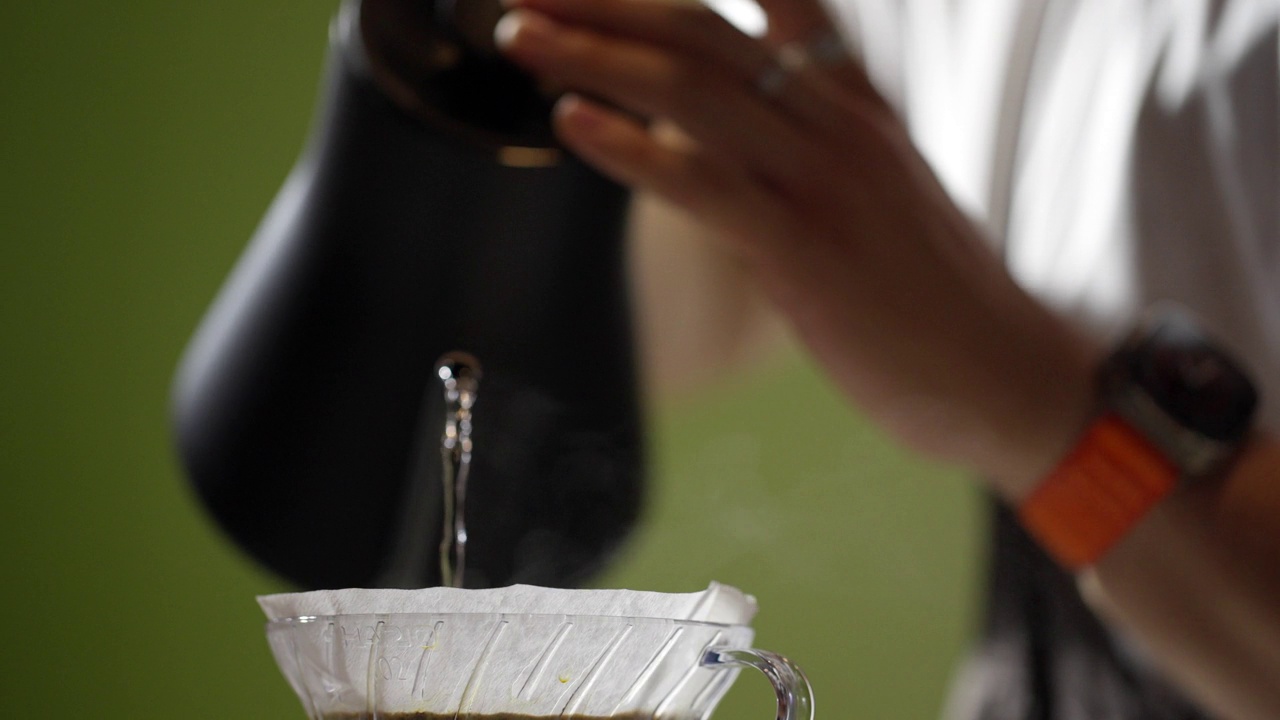 咖啡师通过咖啡过滤器制作手工咖啡。视频下载