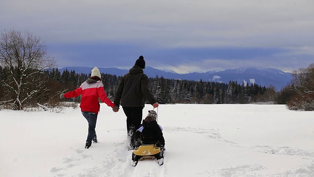 和爸爸妈妈一起玩雪橇视频素材