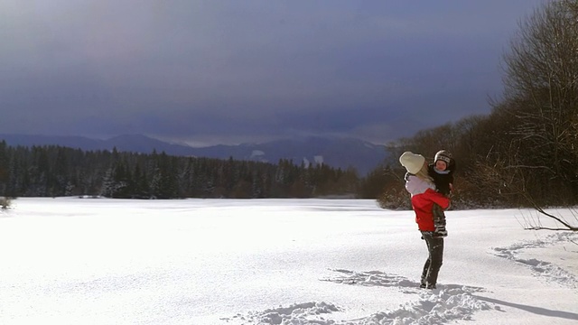 妈妈和儿子在雪中玩耍视频素材