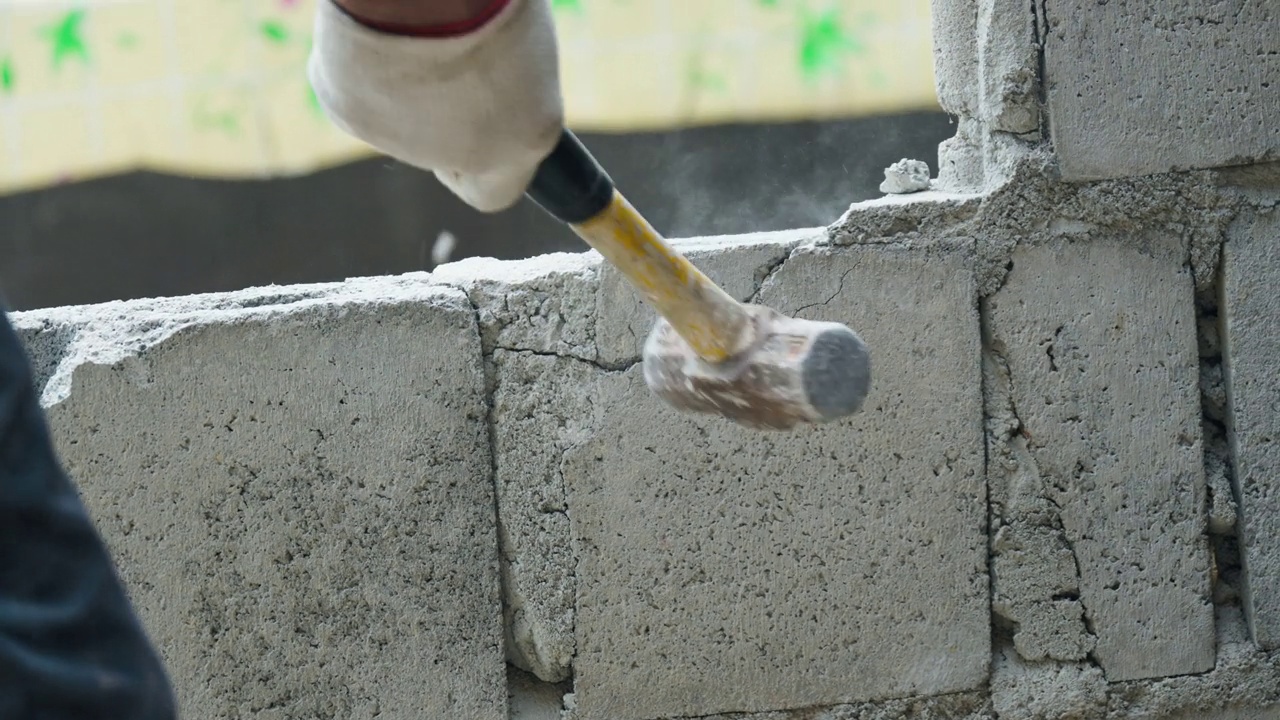 工人在工地用锤子砸砖墙的手视频下载