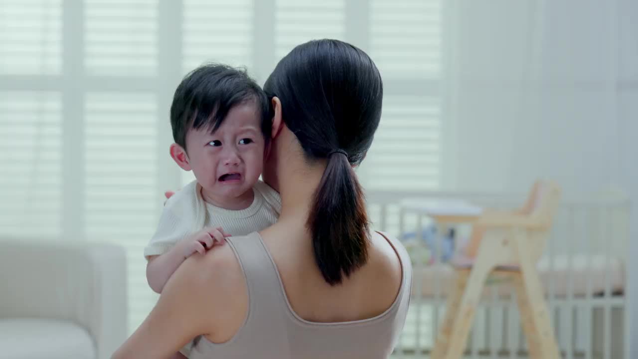 一位年轻的母亲抱着哭泣的婴儿视频下载