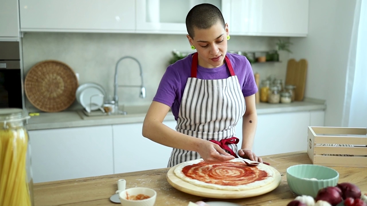 短发女孩在现代厨房里做披萨视频下载
