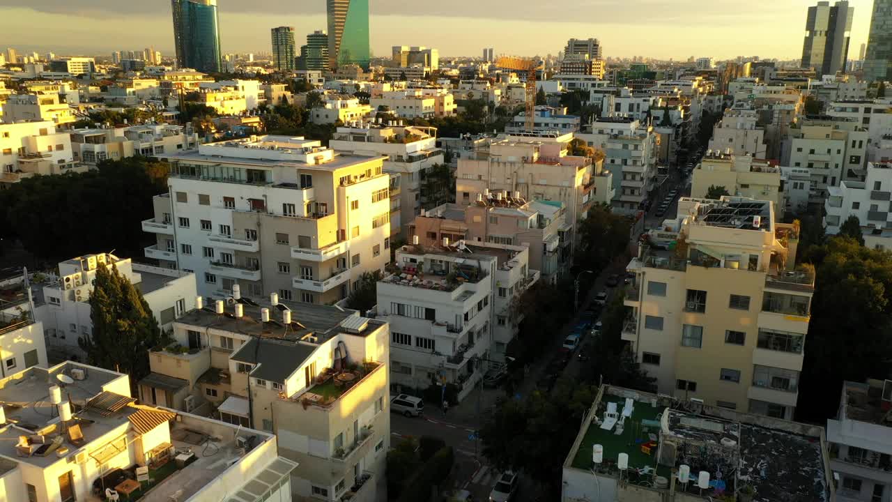 空中拍摄的建筑物和街道上的车辆对天空，无人机上升在城市日落-特拉维夫，以色列视频下载