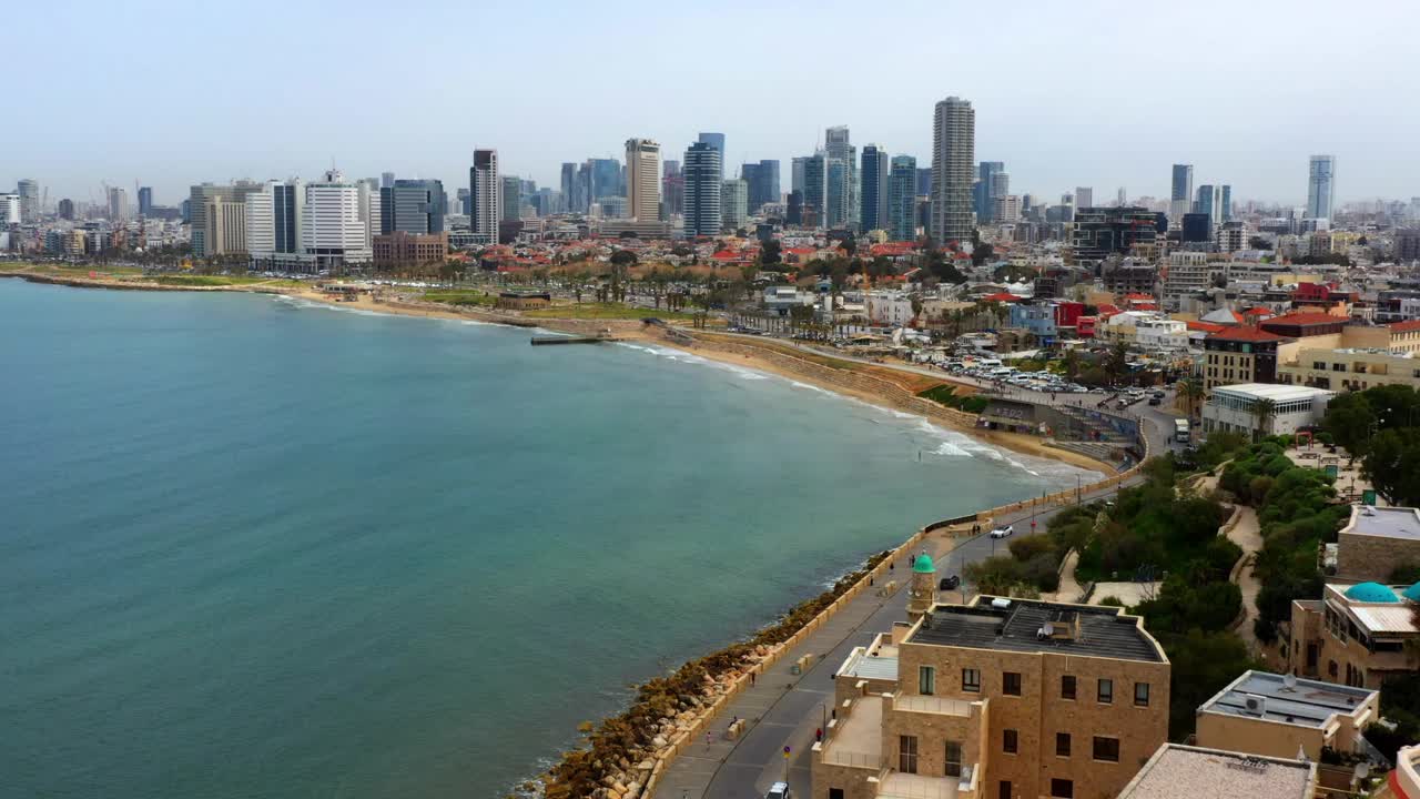 航拍的建筑物附近的海滩和大海在城市对天空，无人机飞行向前的海岸线-特拉维夫，以色列视频下载
