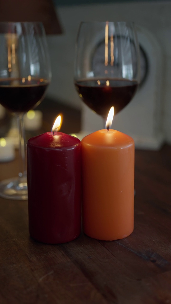 葡萄酒和两个红色和橙色的充满活力的彩色蜡烛视频下载
