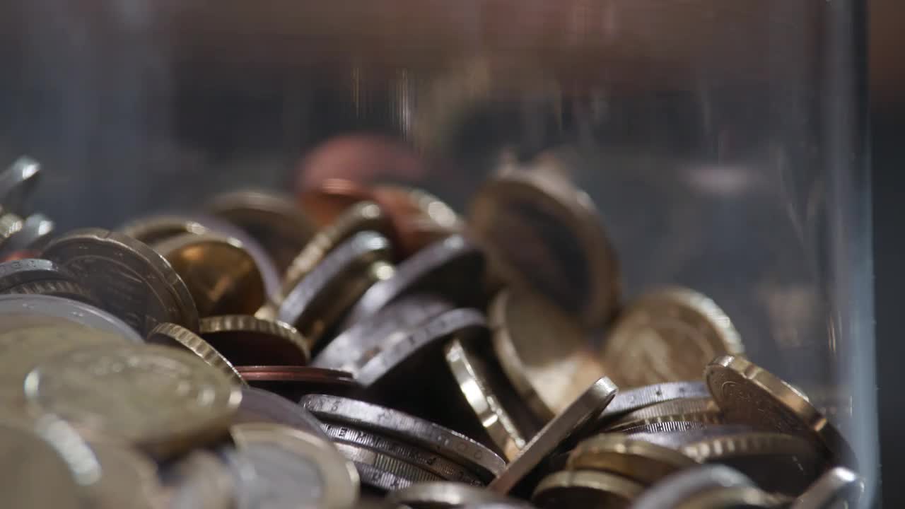 欧元硬币零钱倒在旋转的玻璃罐中，动作缓慢视频下载