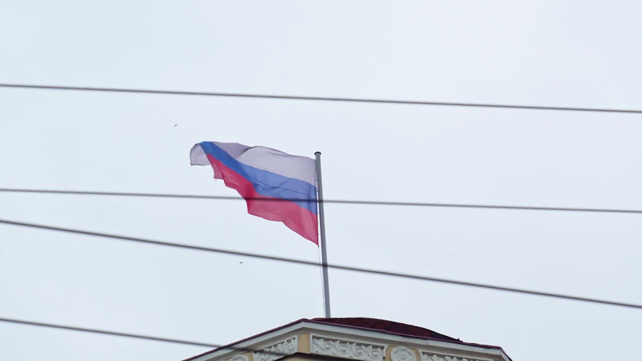 在天空的背景下，建筑屋顶上的俄罗斯国旗。视频素材