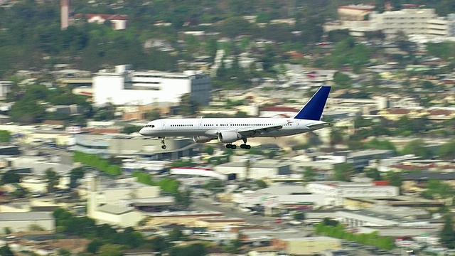 客机飞过城市上空的航拍照片视频素材