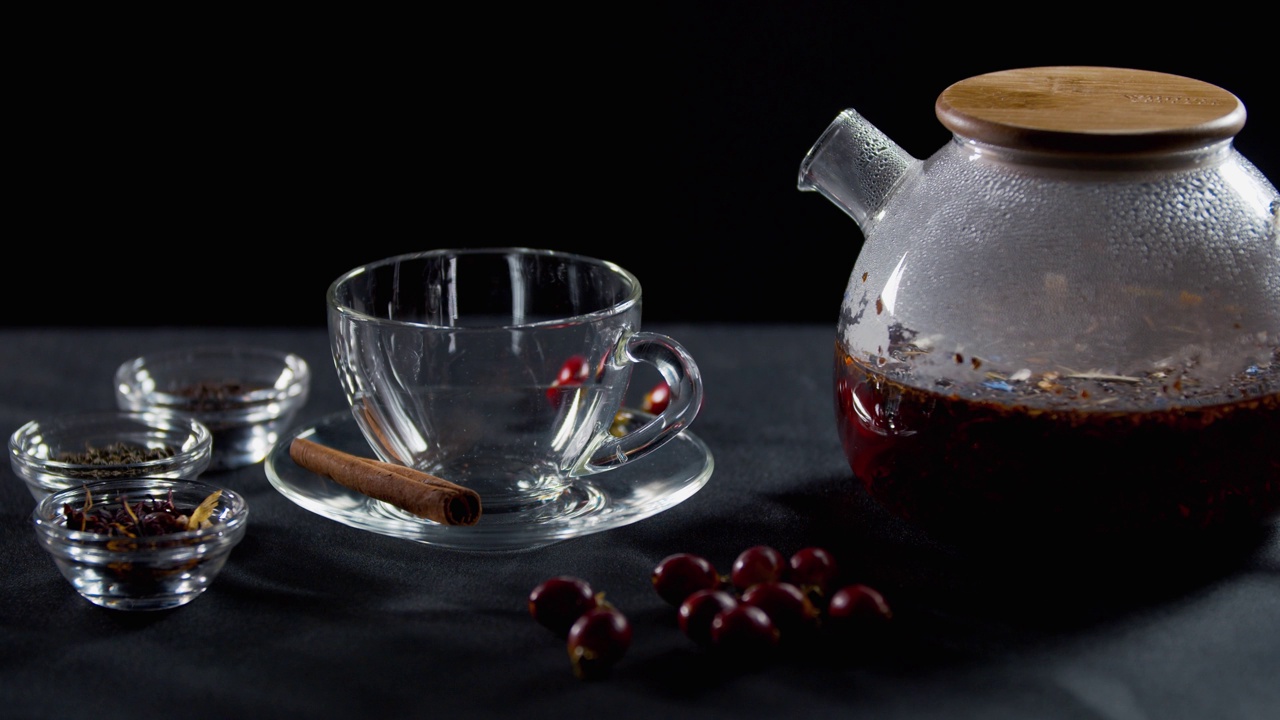 一个杯子，旁边有不同种类的茶，茶壶里有新鲜的热茶，4k视频素材