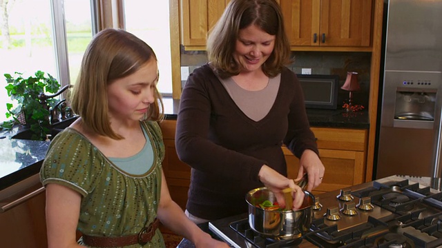 母亲和女儿一起在厨房里视频素材