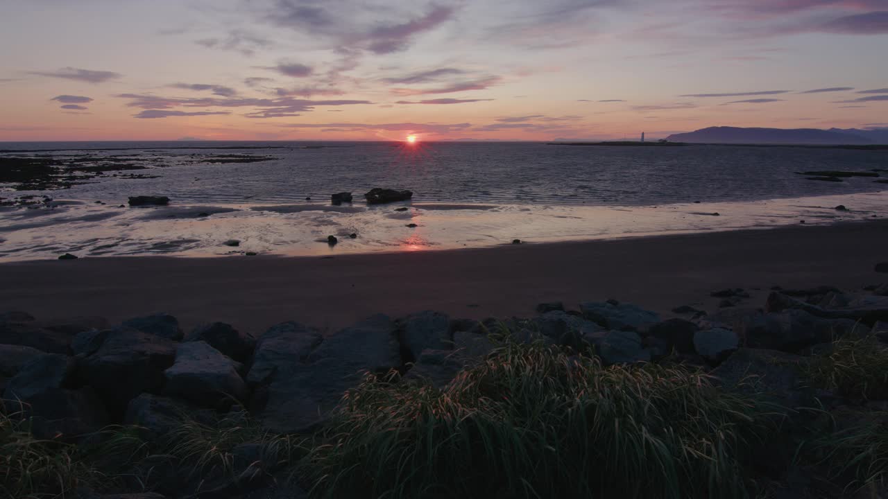 冰岛格罗塔，落日在海风中掠过海洋和海草视频下载