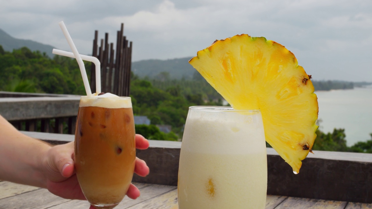 热带饮料:星冰乐和椰子汁椰林朗姆酒。冰星冰乐加冰块和凤梨片冰朗姆酒。电影视频:海边清凉的星冰乐和冰镇朗姆酒。视频下载