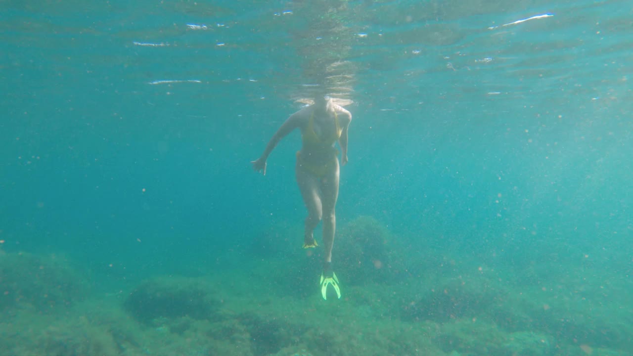 迷人的白种年轻女子在水下面具和呼吸管潜水水下在透明的海水在浅的深度视频素材