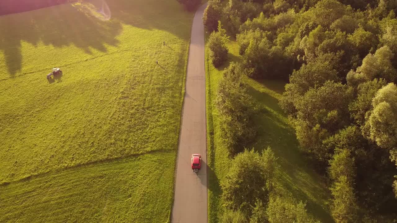 红色汽车行驶在丘陵地带。视频下载
