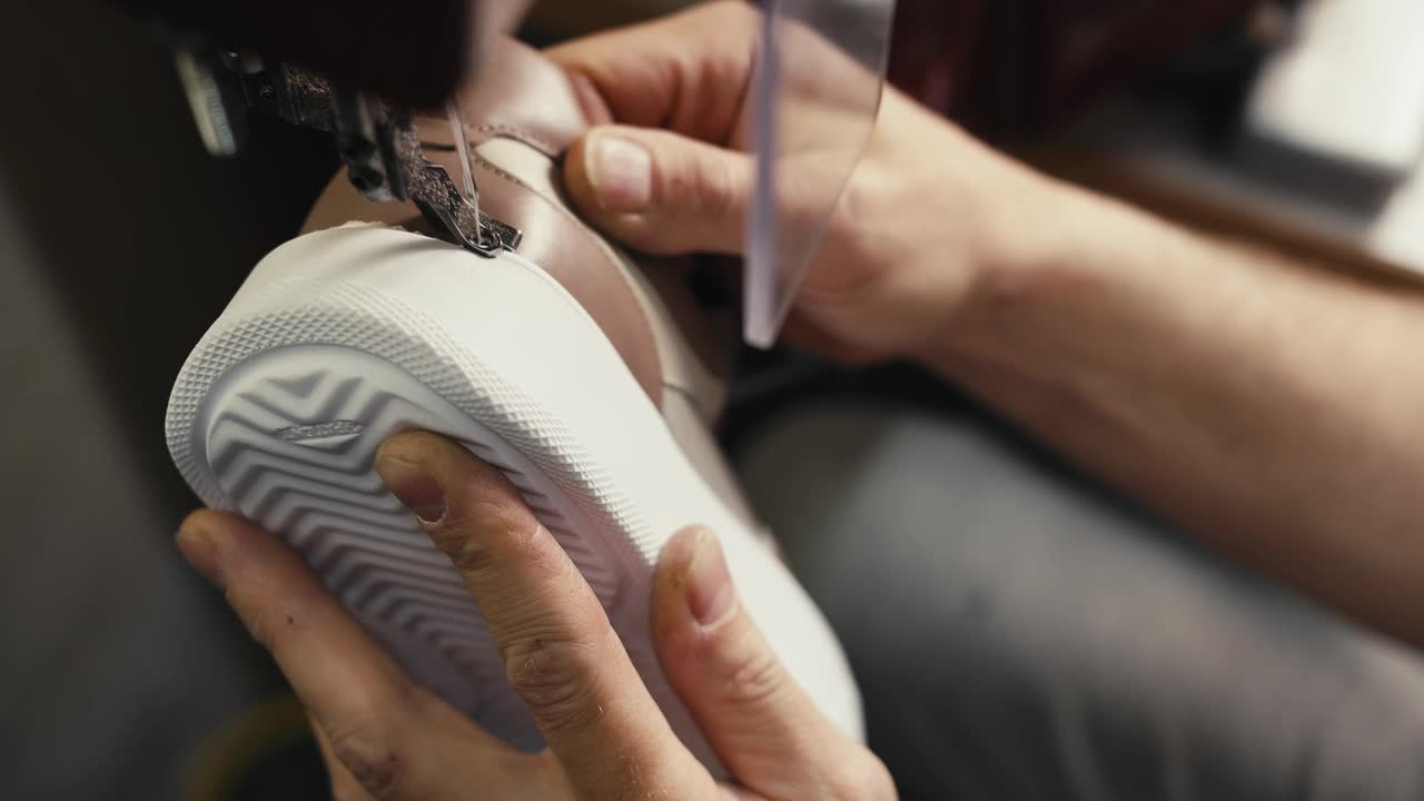 特写镜头:在纺织厂的特制制鞋机上缝制鞋底和鞋面视频素材