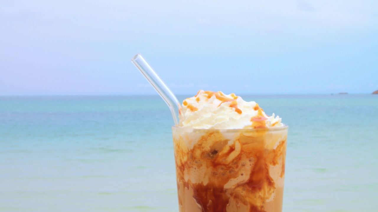 在海上度假，在咖啡馆享用美味的焦糖星冰乐。概念享受暑假在海上与焦糖星冰乐视频下载