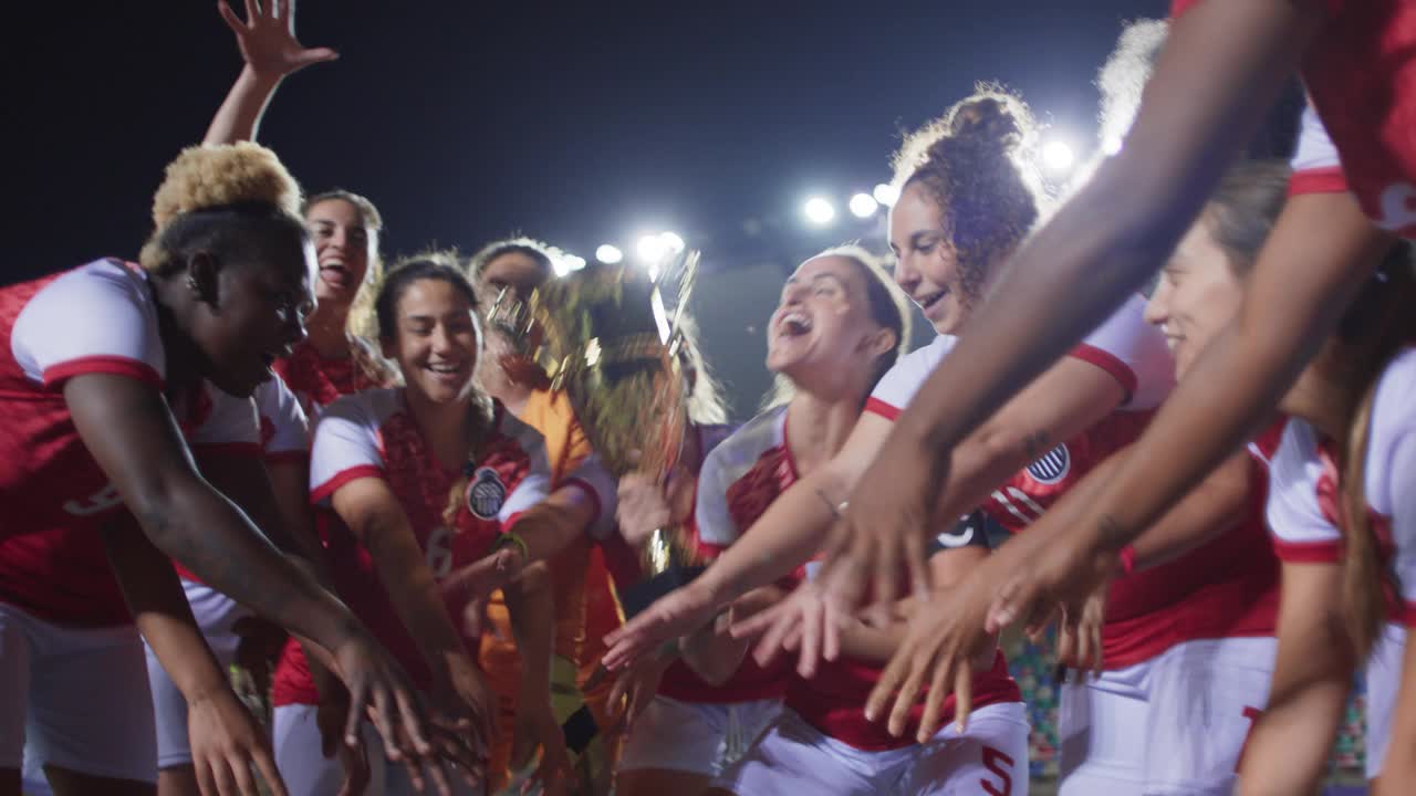 欣喜若狂的女足球队队长亲吻冠军奖杯，五彩纸屑落下，球队庆祝视频下载