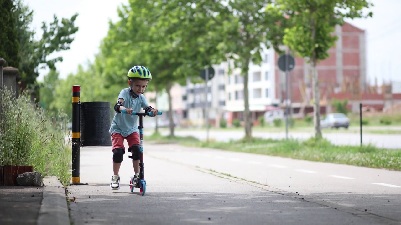 戴头盔的孩子骑着滑板车视频下载