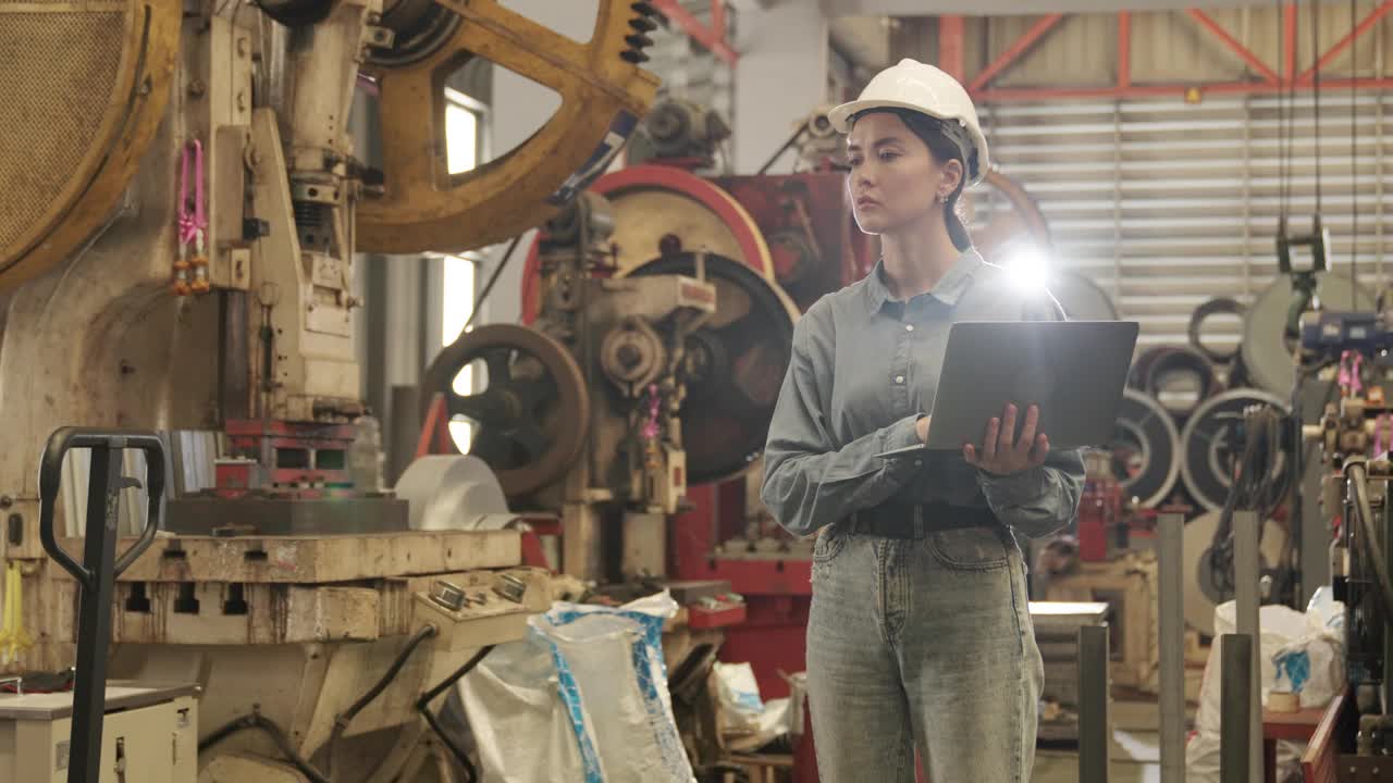 戴着安全帽的女工在大型工厂检查机器视频下载