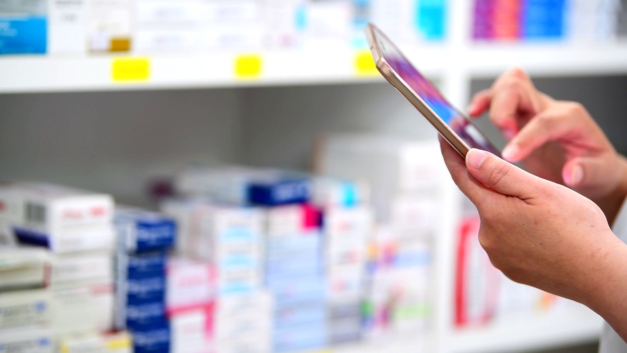 药剂师用电脑平板电脑搜索栏显示在药店货架背景上。。视频下载