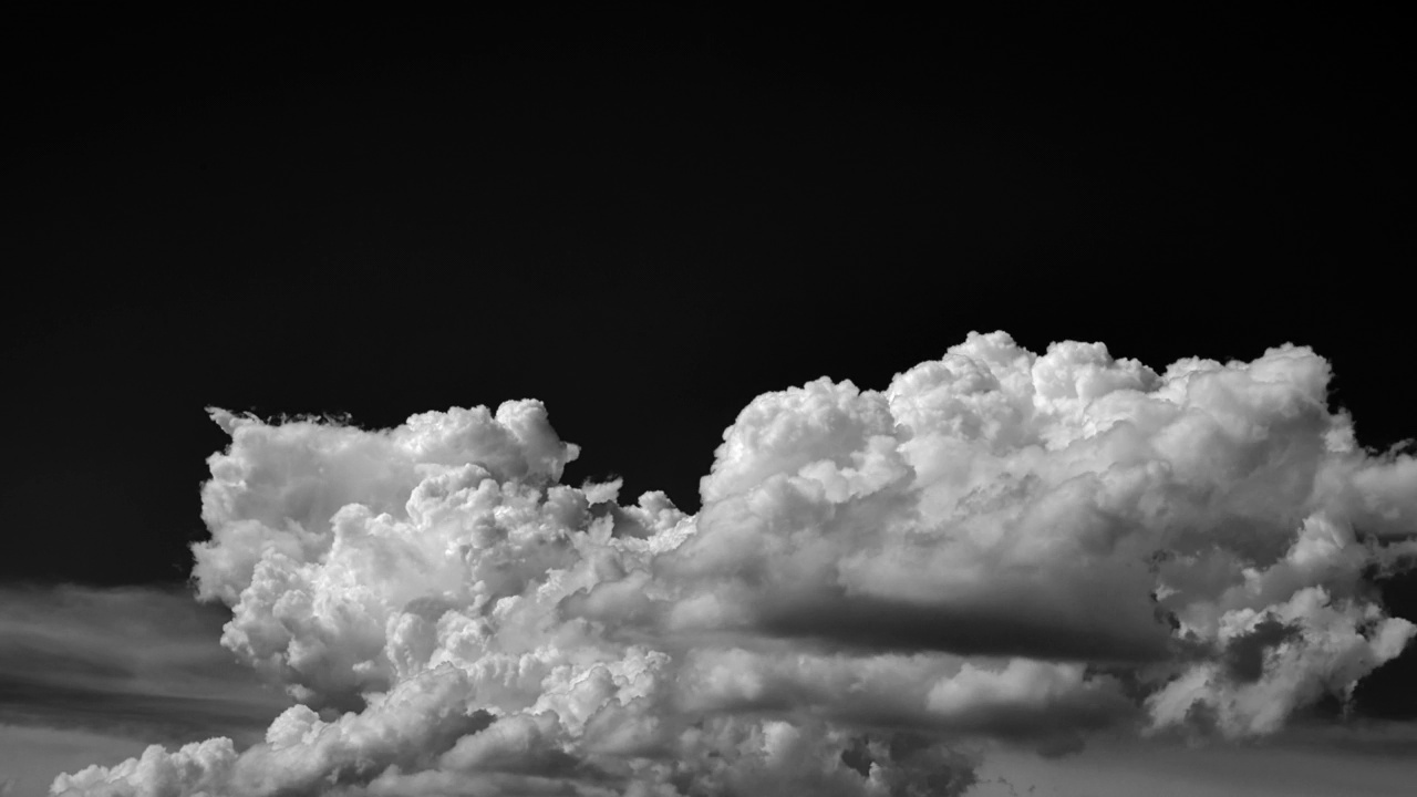 延时拍摄的白云孤立在一个黑色的背景逼真的云。视频素材