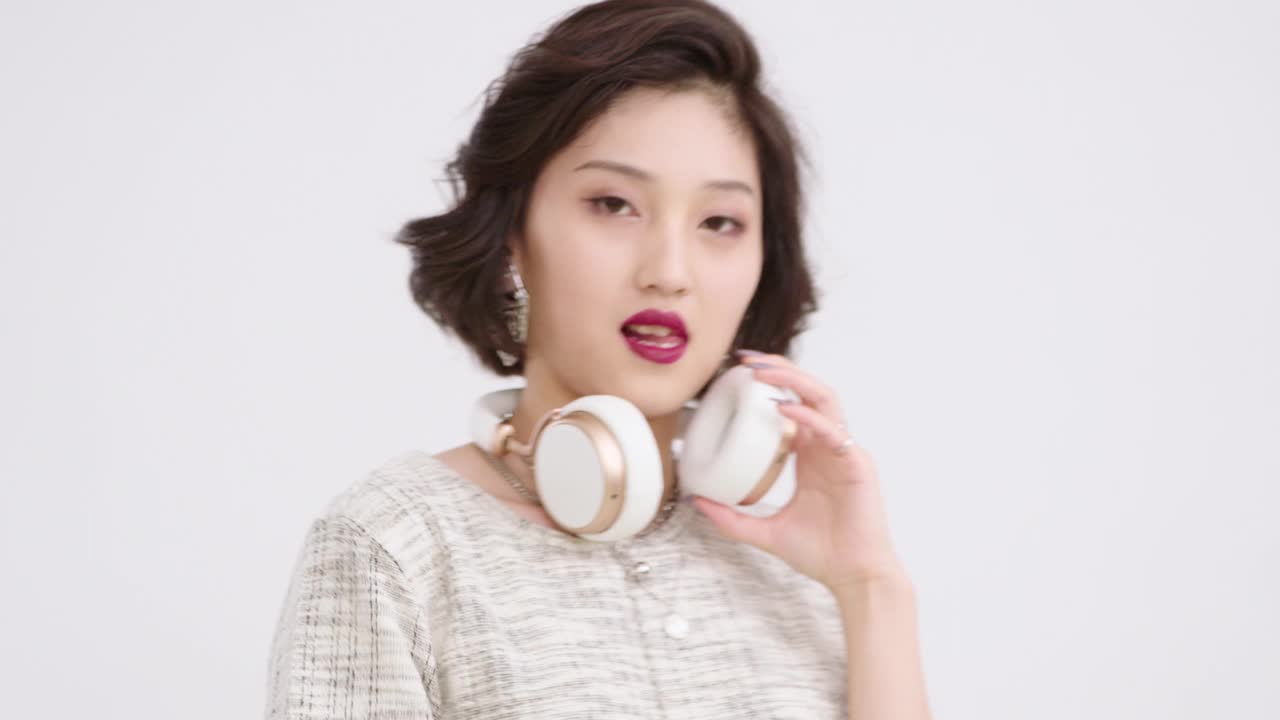 时髦的年轻女子戴着耳机，4K视频下载