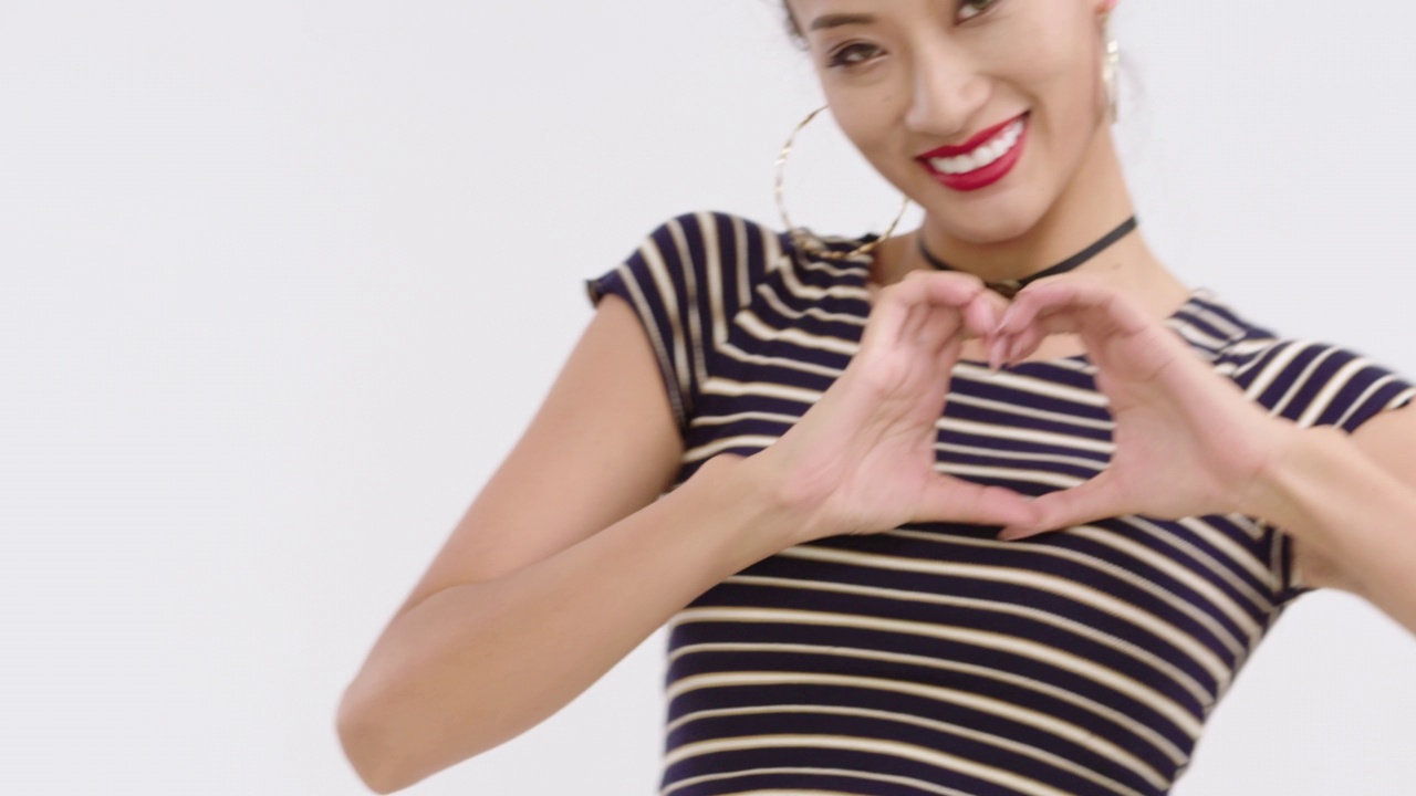时髦的年轻女子做心形手势，4K视频下载