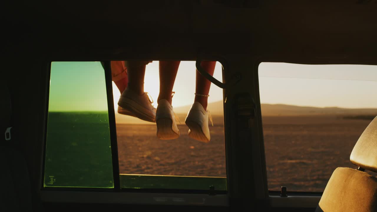 旅行，公路旅行和朋友的腿透过车窗在日落时度假或一起度假。鞋子，夏天和放松的一对妇女坐在一辆车，而在沙漠中旅行视频下载