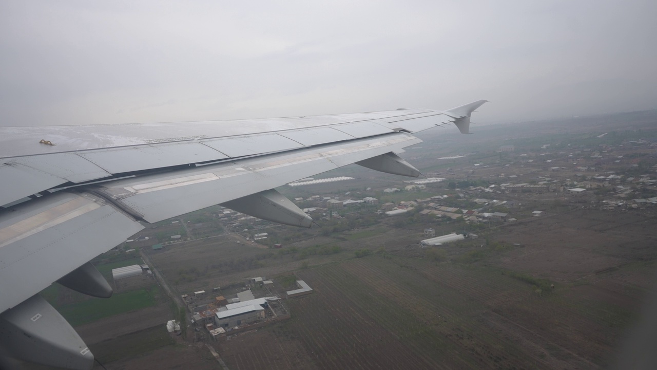 阴天从国际机场跑道起飞的飞机舷窗或舷窗所看到的景象。飞机机翼的第一人称视角。视频素材