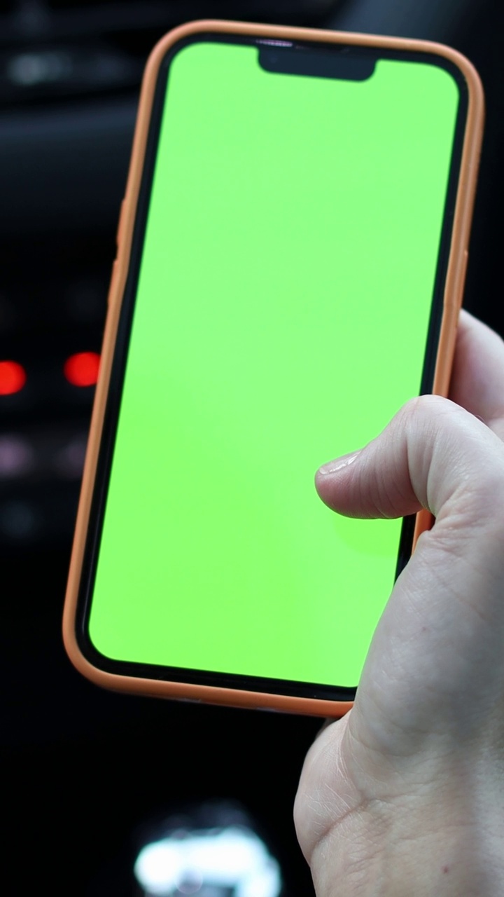 一名女子在车内使用绿屏智能手机视频下载