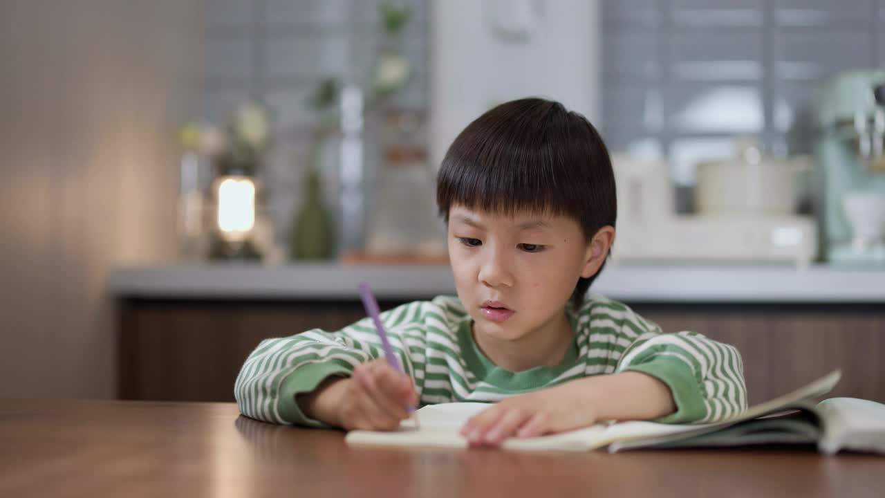 快乐的亚洲小男孩在家做作业视频下载