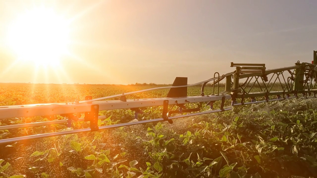 日落时分，喷雾器在大豆地里喷洒农药，慢镜头视频素材