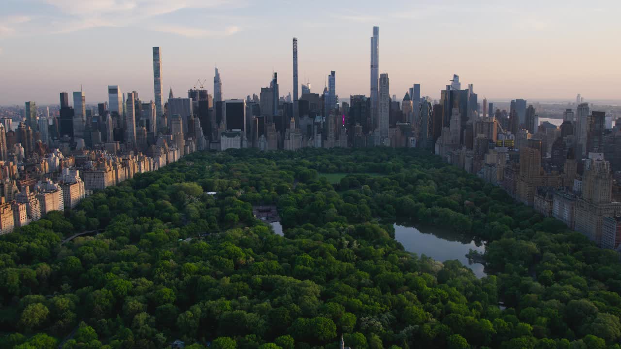 直升机游览纽约市建筑。在温暖的黄昏阳光下，飞越中央公园，俯瞰曼哈顿的办公大楼和摩天大楼全景视频下载
