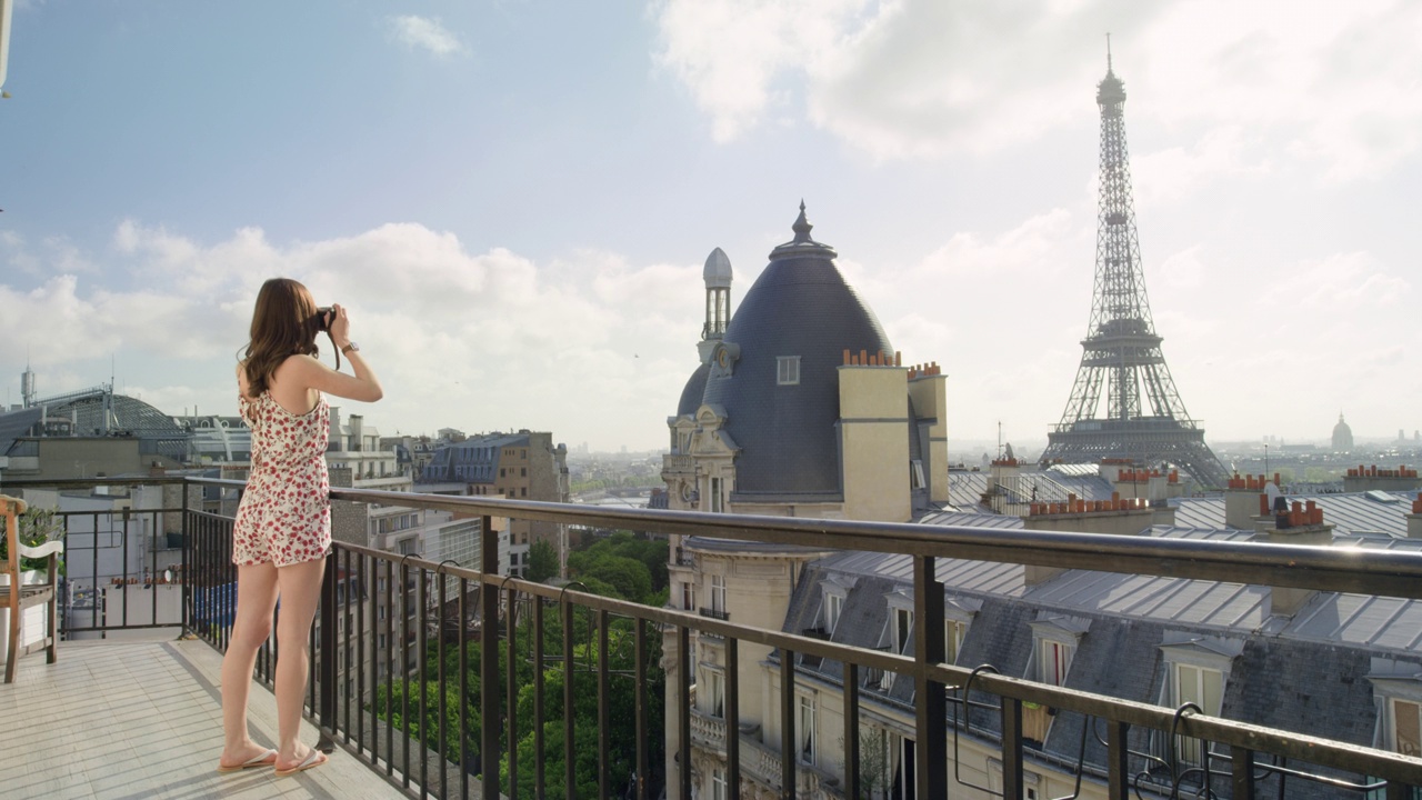 一名女子在日出时用智能手机在酒店阳台上拍摄埃菲尔铁塔，拍摄巴黎风景优美的城市景观背景，享受欧洲蜜月假期旅行冒险视频下载