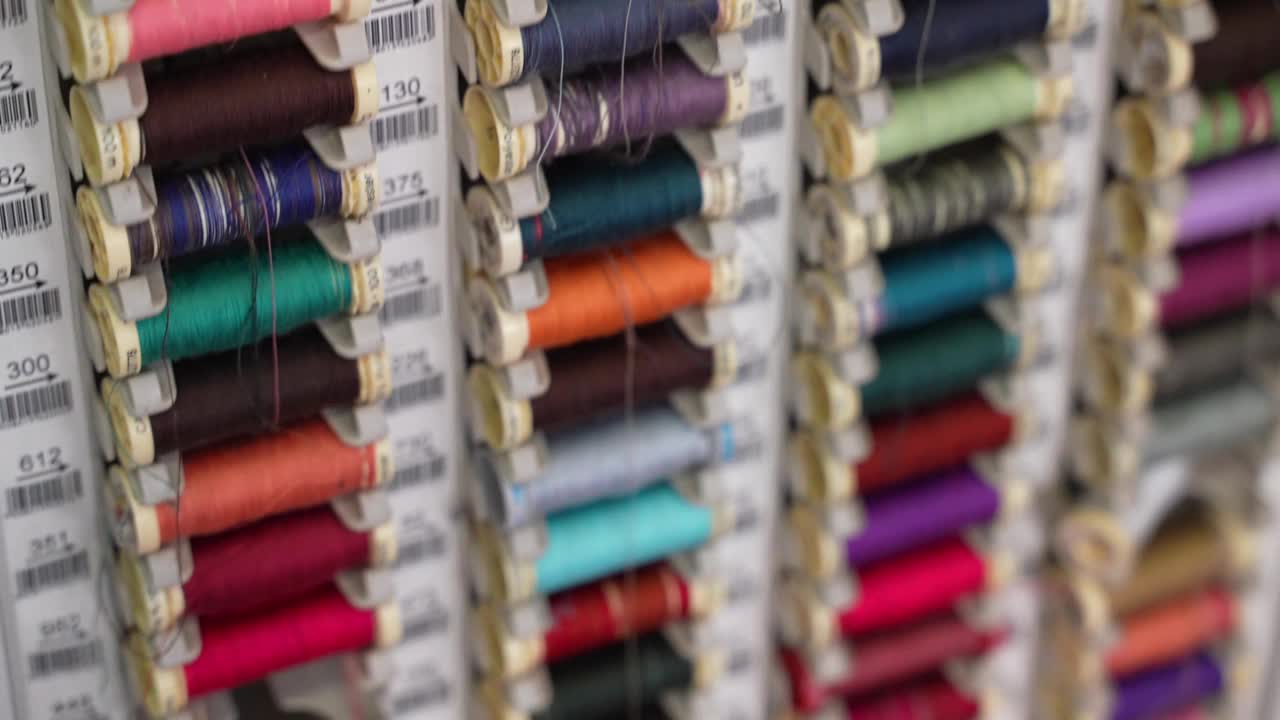 裁缝车间特殊垂直板上的彩色棉线线轴，专业缝纫机的线卷，纺织工业的织物线，针线概念视频素材