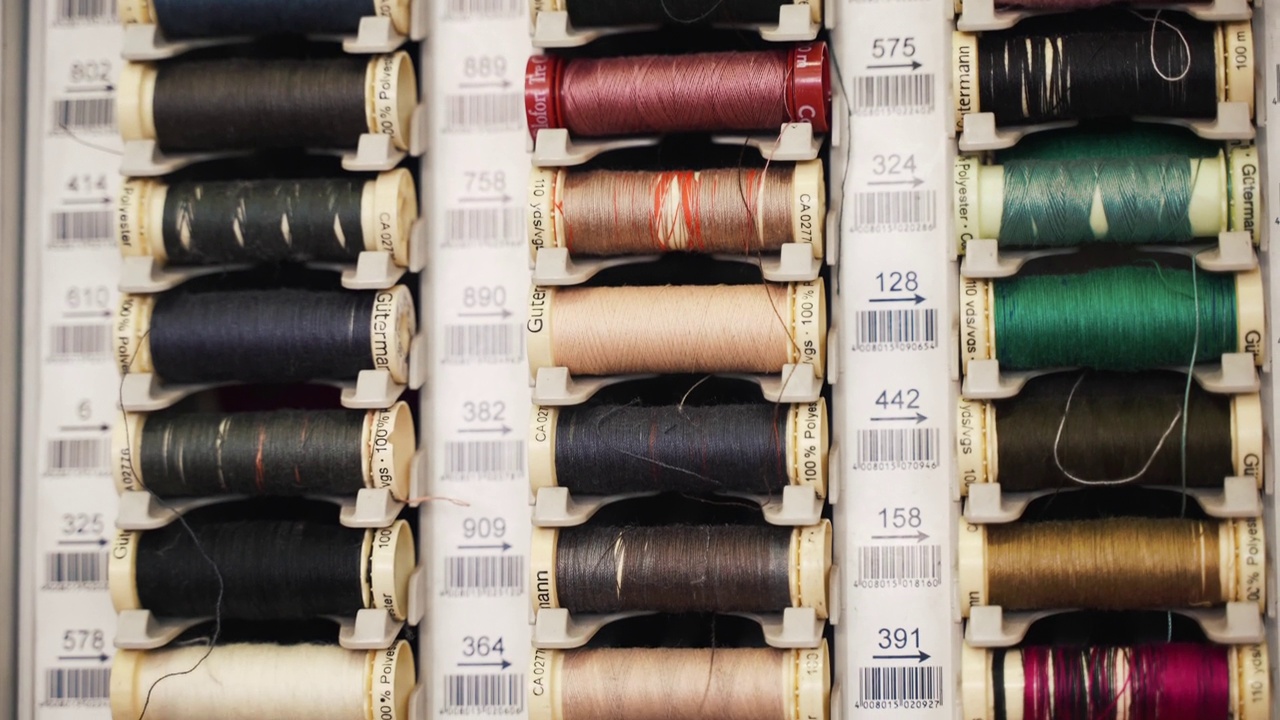 裁缝车间的一排排彩色棉线线轴，专业缝纫机的线卷，纺织工业的织物线，缝纫工具，材料和设备的概念视频素材