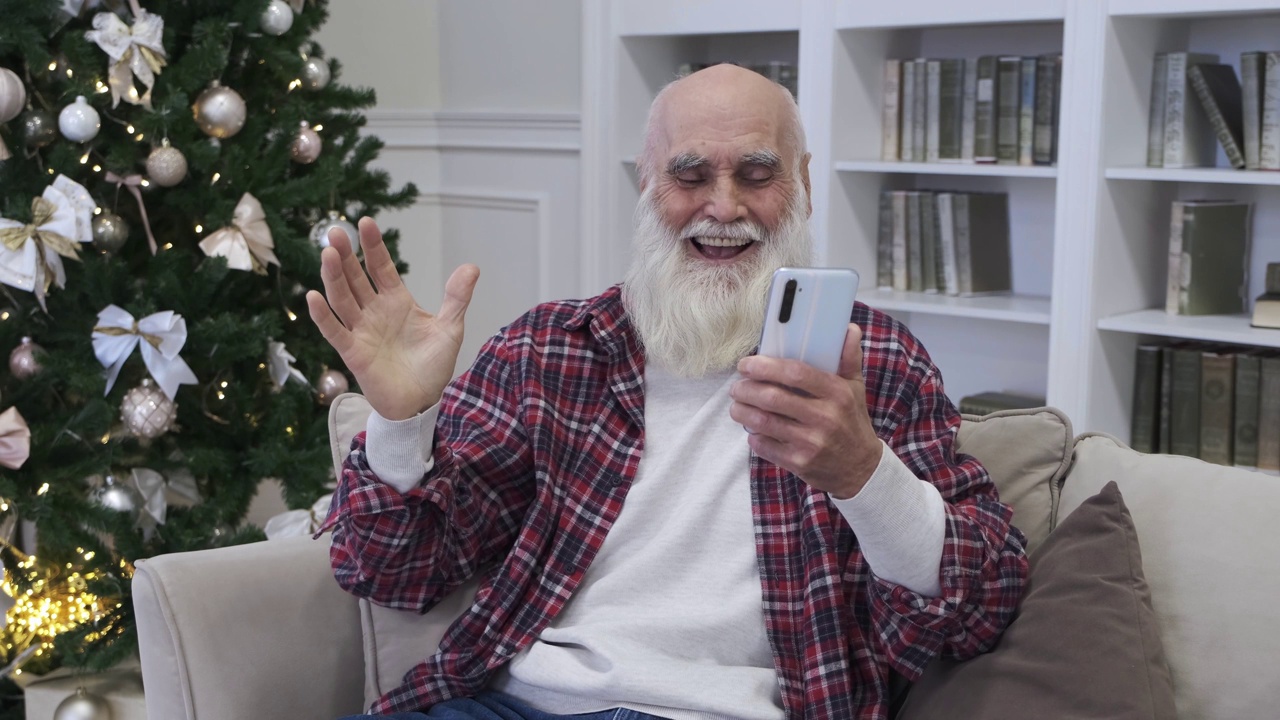 开朗的老人喜欢在家用智能手机看搞笑视频视频下载